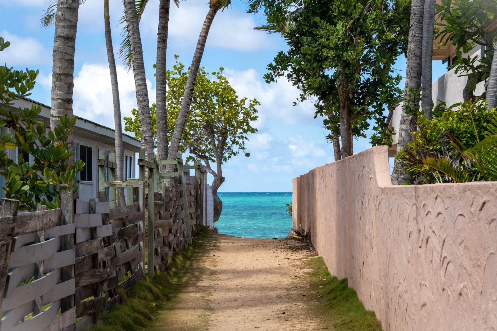 Sandy lane between homes leading to turquoise water at Lanikai
